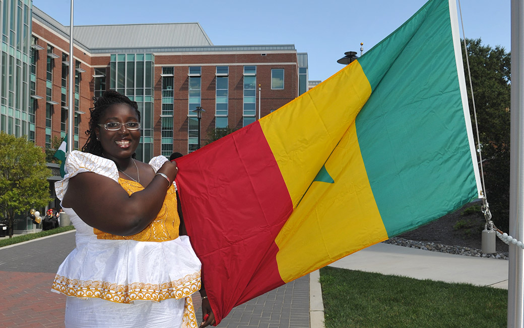 student standing next to a flag