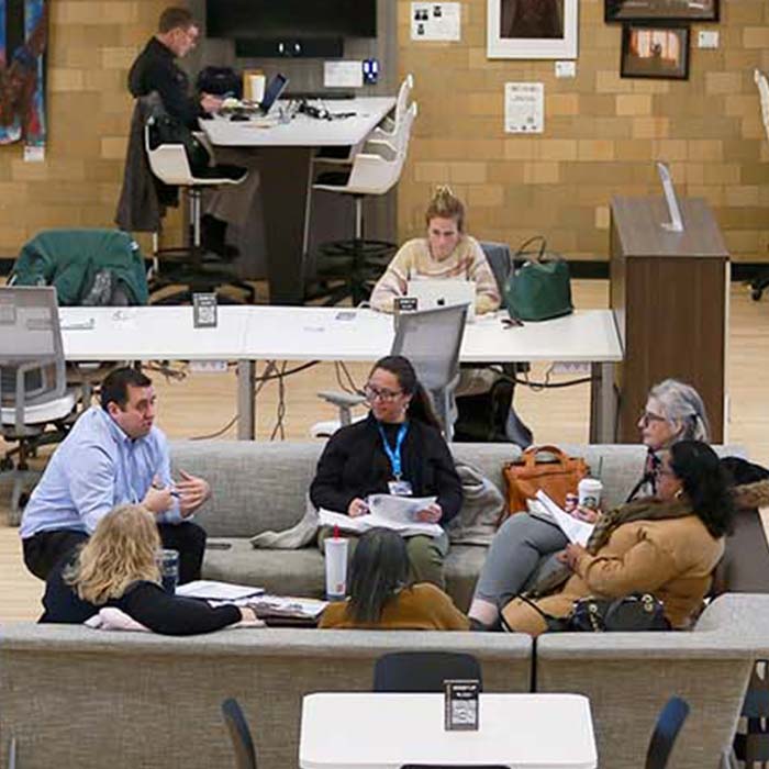 a group of people in the shared space having a work discussion