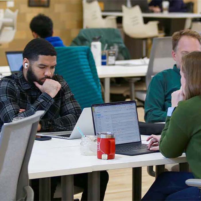 individuals working on laptops in the shared space