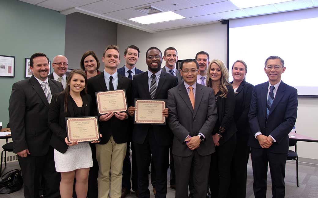 The winning student team, holding certificates (front row from left) Christina Basuino, Sean O'Grady and Segun Adeniji with the judges from Cintas and Professor Precha Thavikulwat, the adviser of the winning team (far right).