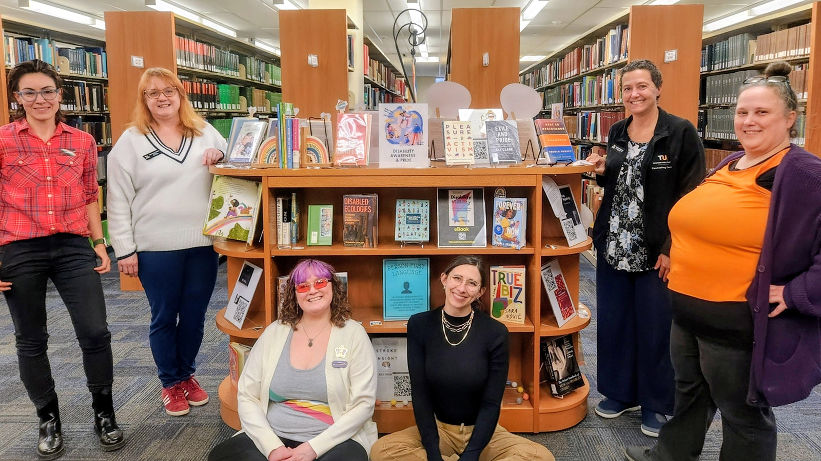 members of the disability+ faculty staff association at a cook library book display