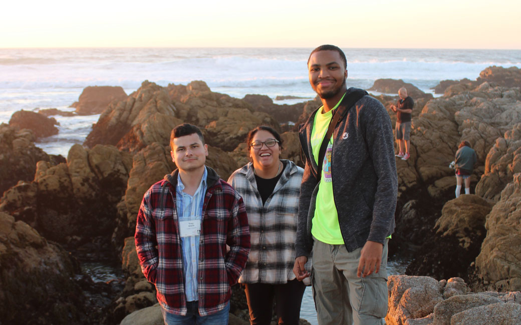 Students stand on coastline in Monterey, California