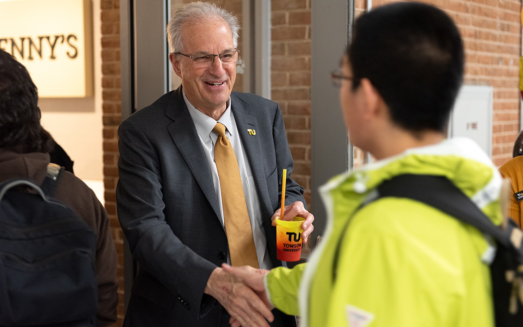 TU President Ginsberg shaking the hand of a TU student