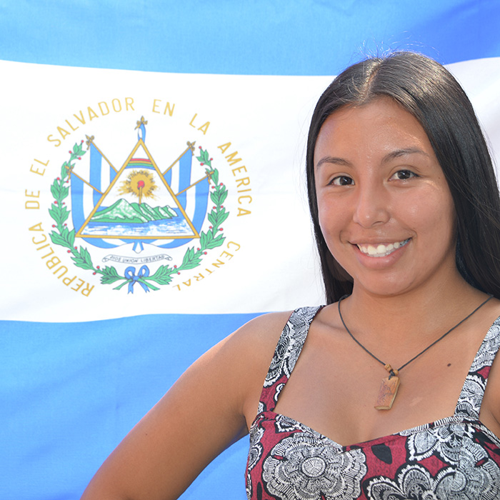 student in front of flag of el salvador