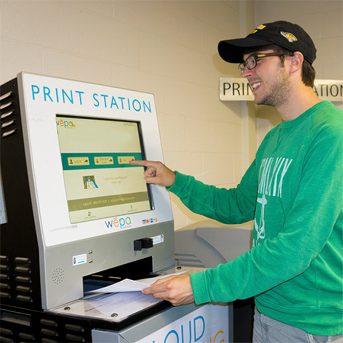 male student using printing kiosk