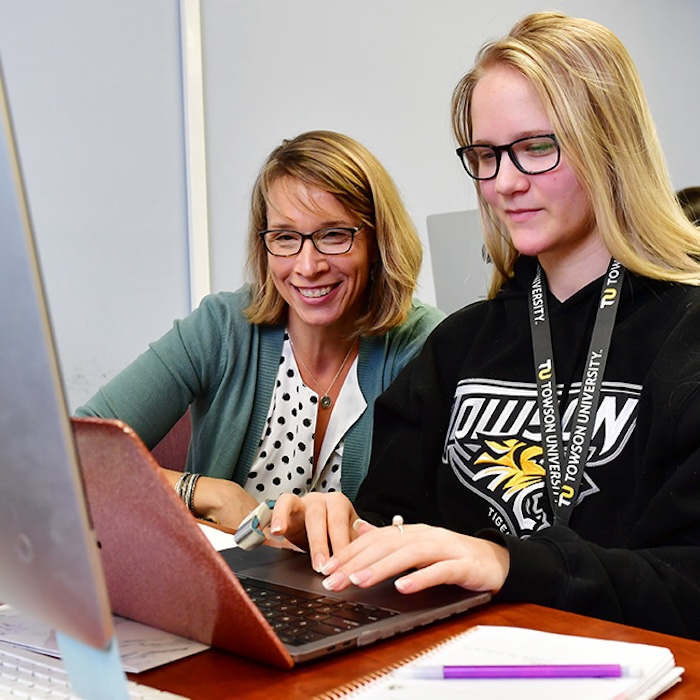 woman helping a student find something online