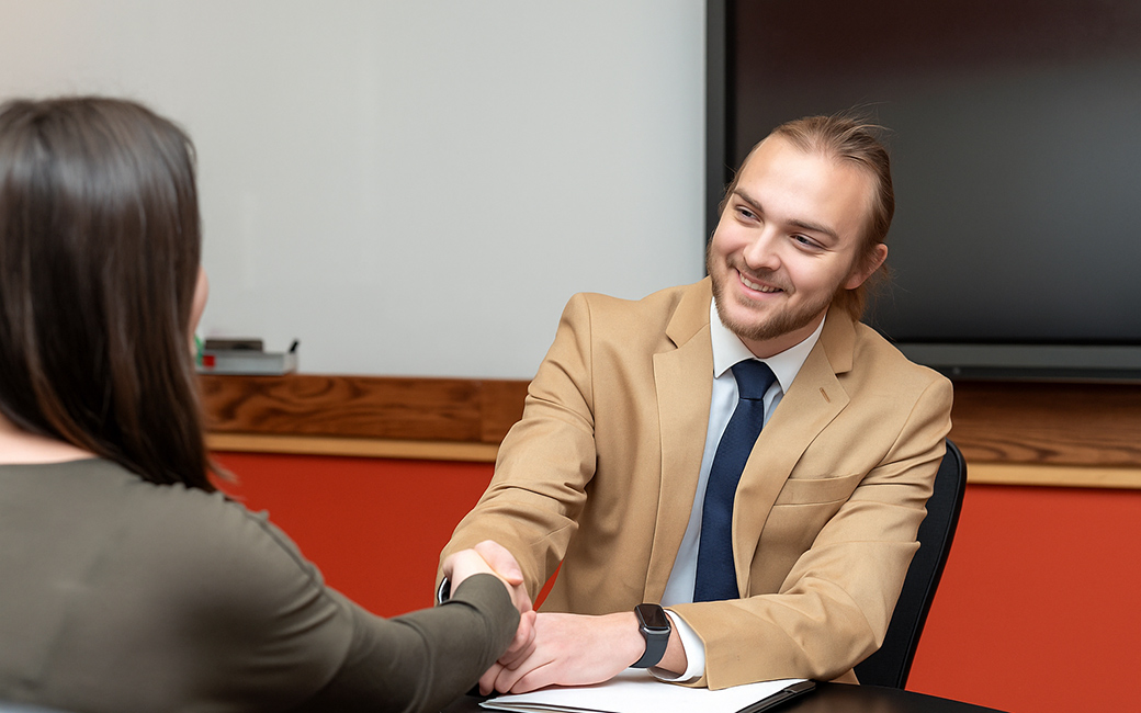 Student shakes hand during one-to-one presentation