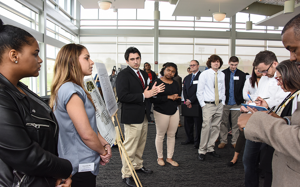 entrepreneurship students deliver a pitch during a poster competition