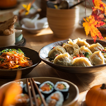 Home-cooked dishes, afternoon sunlight, and autumn leaves make this dinner table look warm and welcoming