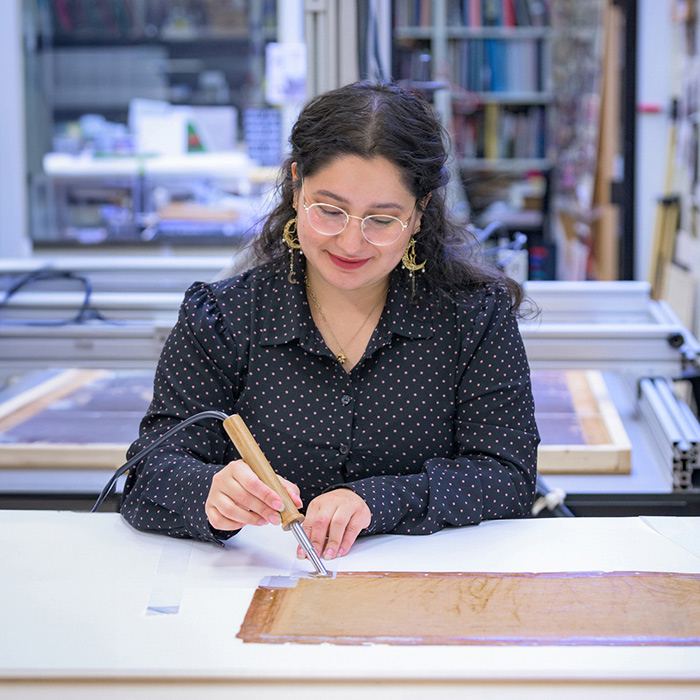 Art conservator Adriana Benavides works on restoring a piece of artwork