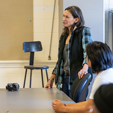 Faculty member in discussion with students in classroom