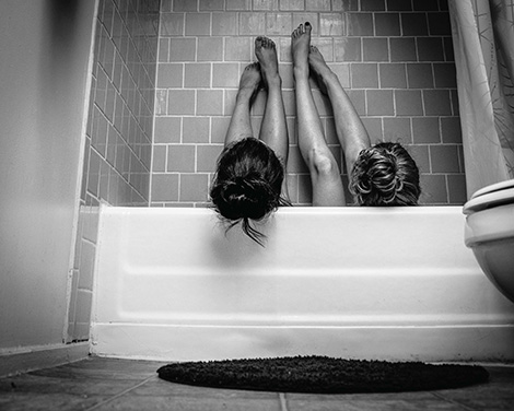 student photograph - two women in tub with legs up