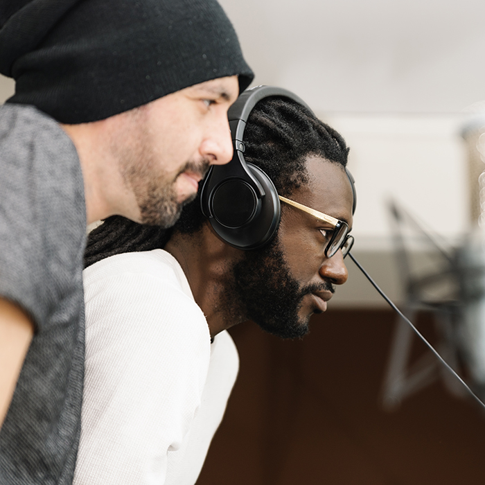 Two musicians listen to the playback of a recording made in the studio