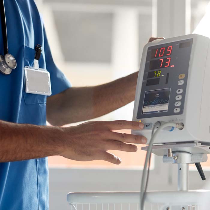 close up ekg technician hands using ekg machine