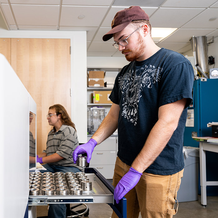 Simon Buccholz and Zachary Greenwald measuring samples on the XRF