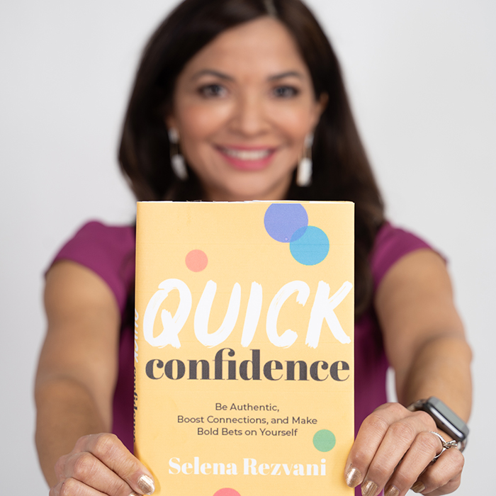 Selena Rezvani holding her book Quick Confidence