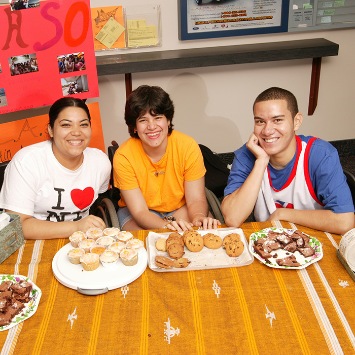 Group of three people sitting around a table