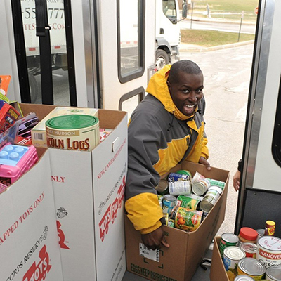 A student donating canned goods to the needy