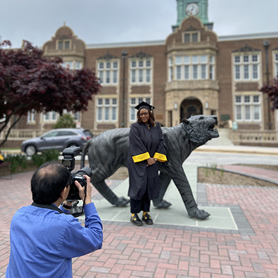 TU Photographer with student in graduation gown