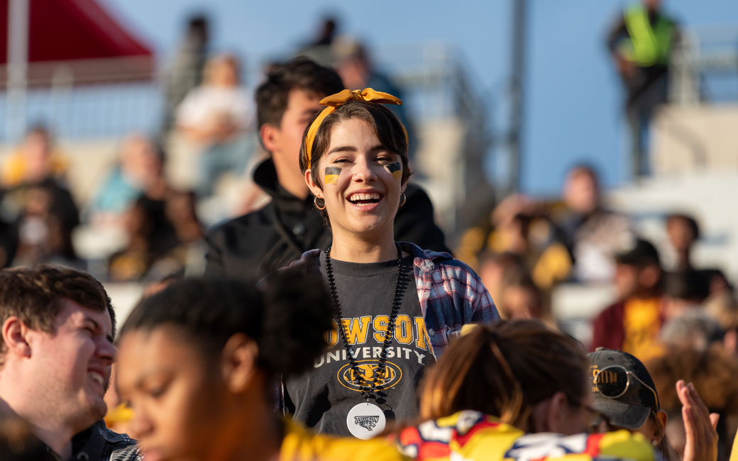 A fan smiles for the camera while standing in the crowd