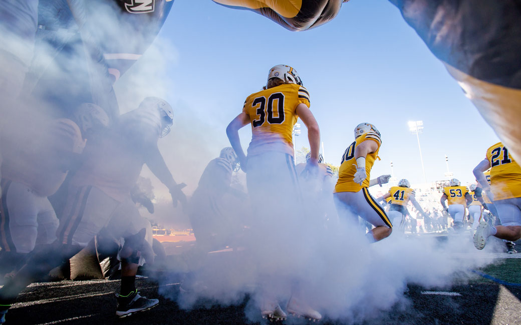 The Towson Football team runs out of the tunnel before the game