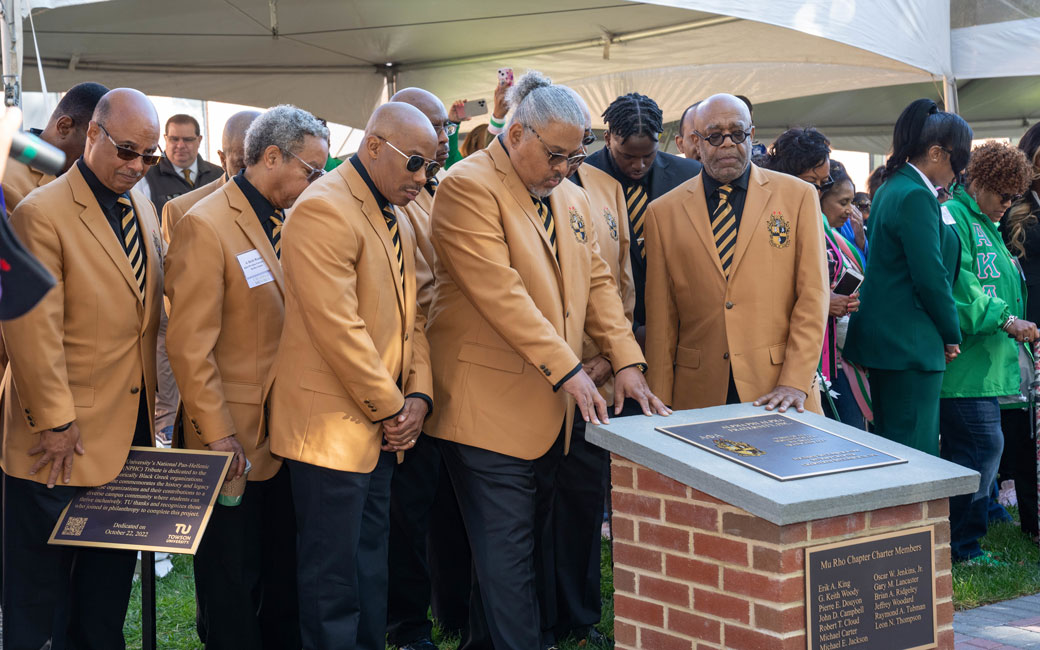 Members of TU's Alpha Phi Alpha Fraternity look over the pillar dedicated to them at the new NPHC Tribute Walkway