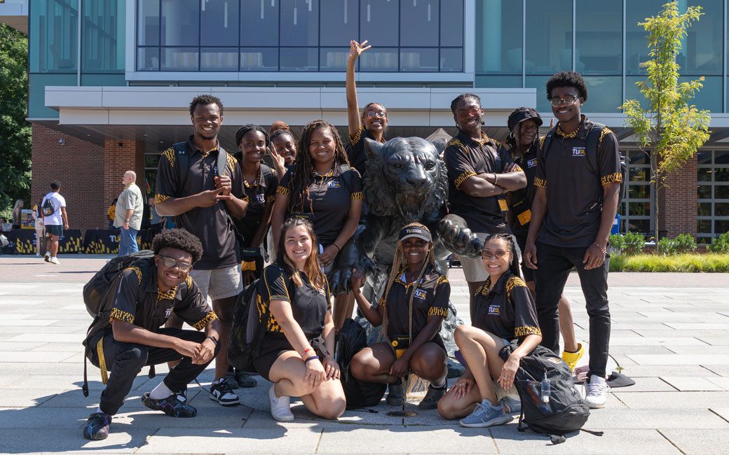 Orientation Leaders posing at a Tiger Statue