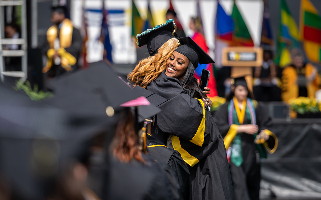 graduates hug