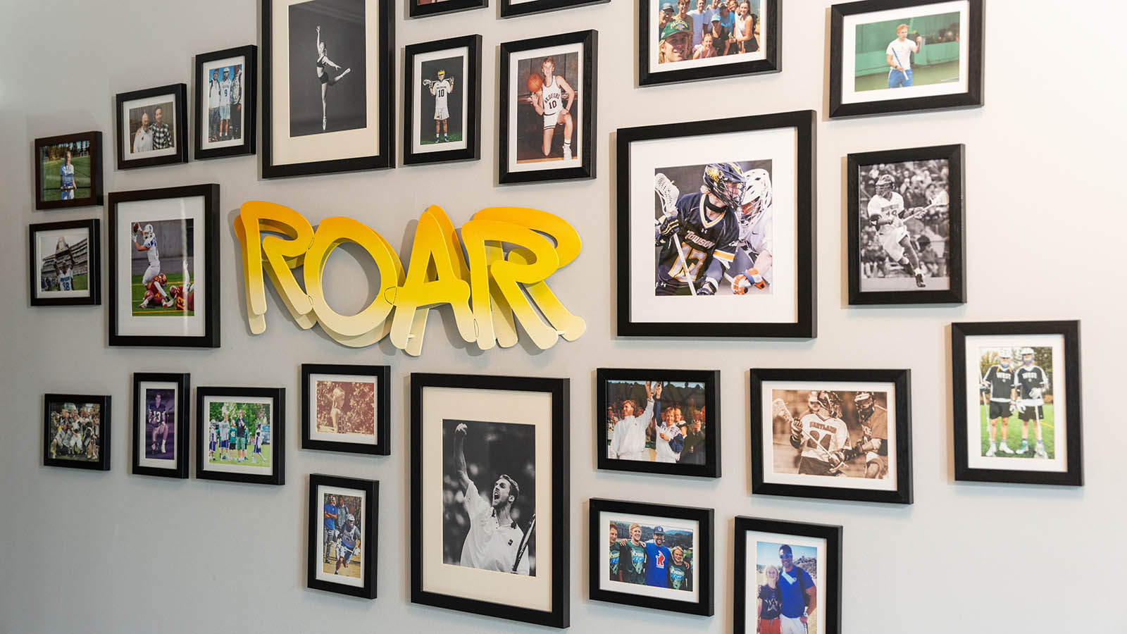 Photo gallery in a house with a light up sign that says "roar"