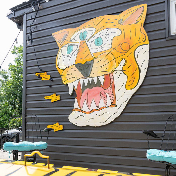 Exterior of a house with a 3-eyed tiger face wall art