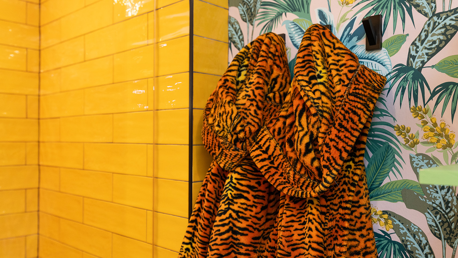 Tiger print robes hanging in a bathroom