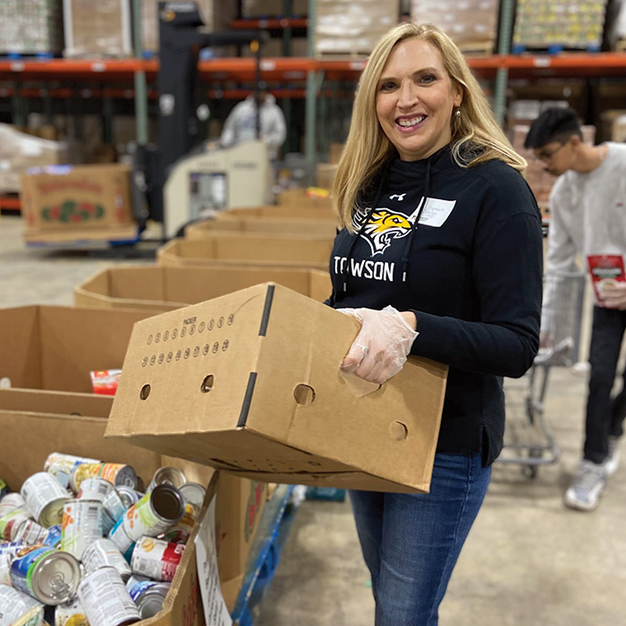 TU alum carrying boxes at the Maryland Food Bank