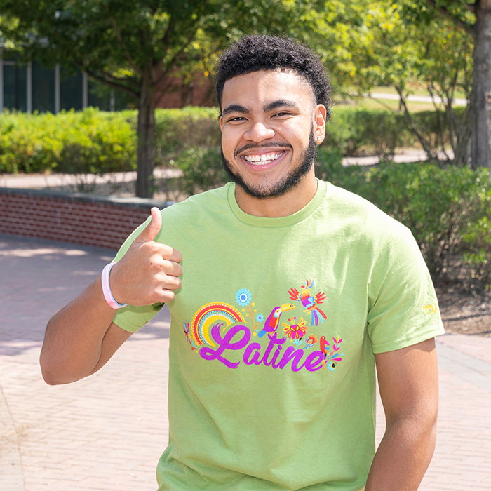 TU student smiling and wearing a shirt that reads "latine"