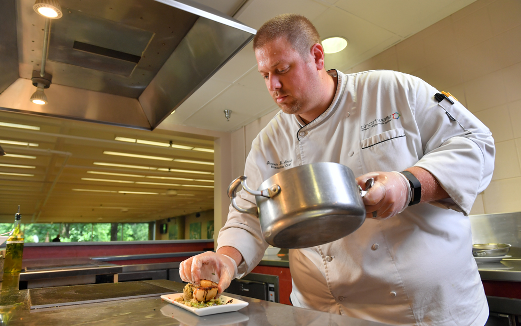 Chef Steve Amrein plating a scallop