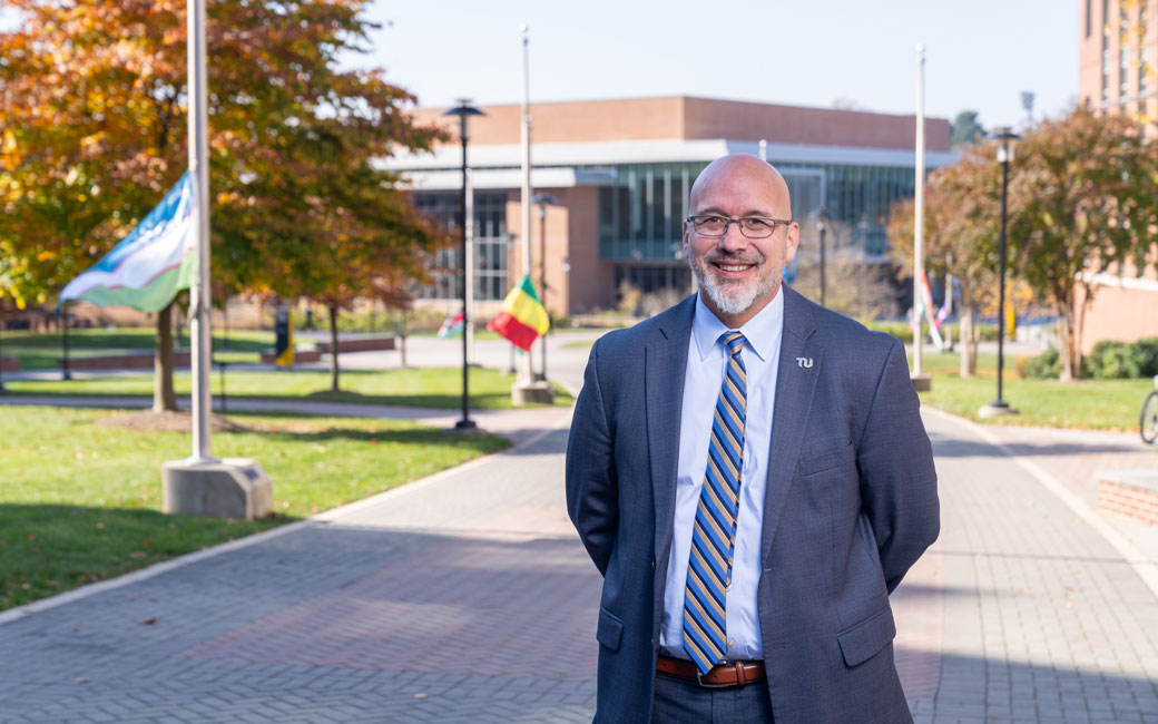 Man stands in front of International Walkway at TU
