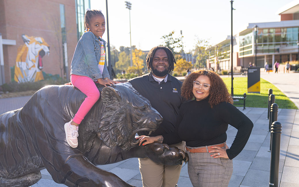 Dajaha Kenney (right) is pursuing a cell and molecular biology major with an MB3 minor with the support of her daughter Autumn (left) and husband Ansel. (Alex Wright | Towson University)