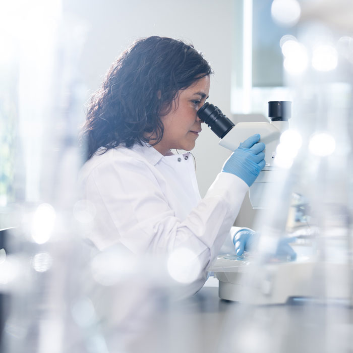 Daniela Chavez focusing on a microscope