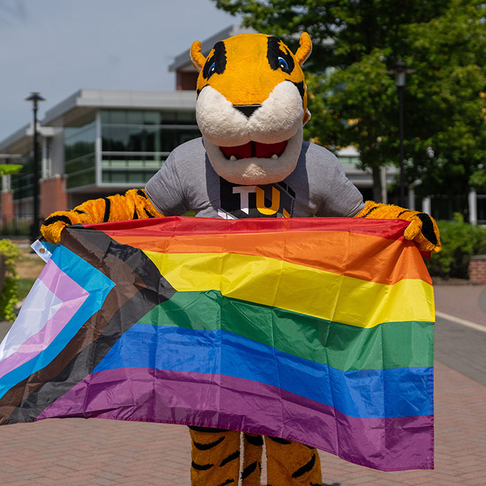 doc holding the LGBTQIA+ flag