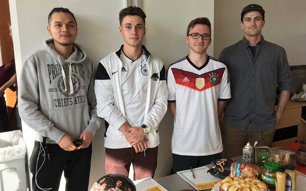 (l-r) Marco Preiner, ’18, Regis Breen, ‘18, Alexander Jantsch, ‘17,  and Matt Conner, ‘17, prepared their German table for the Foreign Languages Day, including German potato salad, candies, pastries, beer steins and a soccer ball.