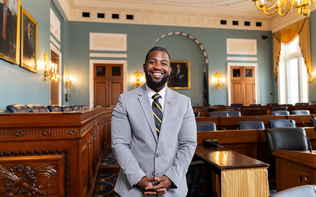 Alum Jamal Washington stands on the floor of the Committee on Agriculture hearing room in the Longworth House in Washington DC