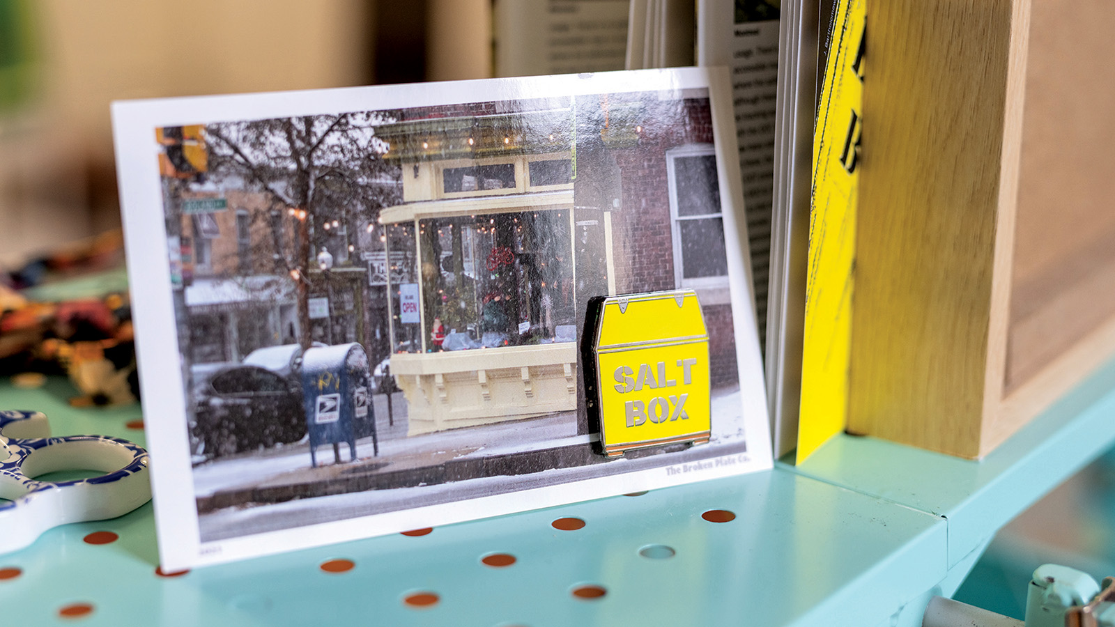 Postcard with a picture of the outside of a shop in Baltimore as it snows