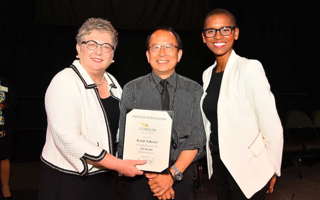 Kanji Takeno pulled triple duty as a service award honoree, a USM Board of Regents staff awards finalist and event photographer at the 48th-annual TU Service Awards Celebration. He is flanked by President Kim Schatzel (left) and Vice President, Marketing Communications Marina Cooper. 