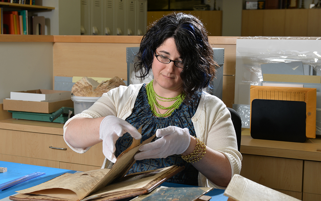 Former archivist Nadia Nasr turning the pages of a book