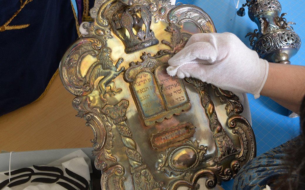 Silver shield and finial used to adorn Torah scrolls.