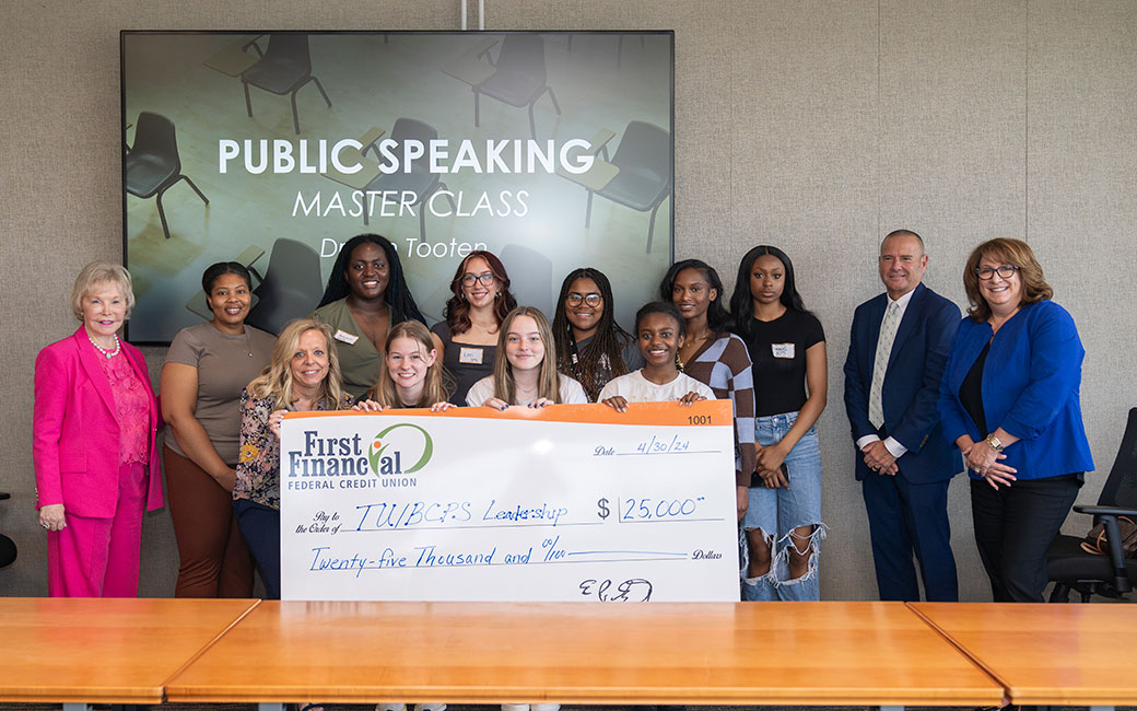 Group of students and professionals with large check for $25,000 dollars.