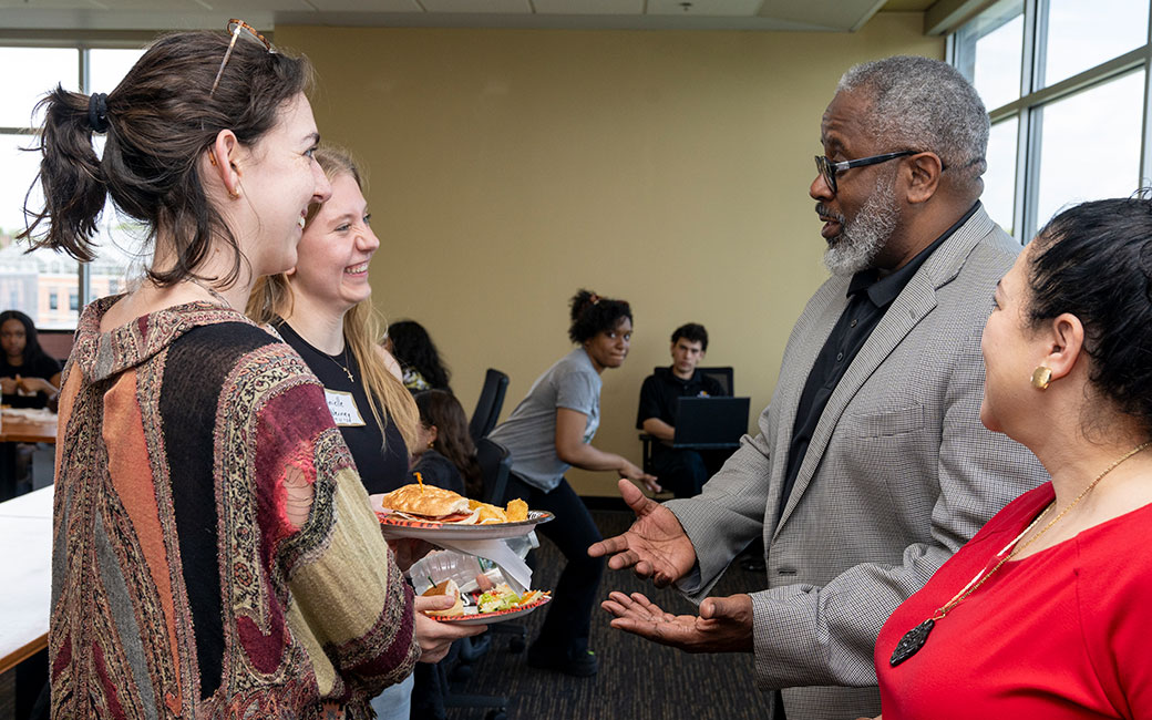 Tim Tooten talking to Dean McCartney and two TU students.