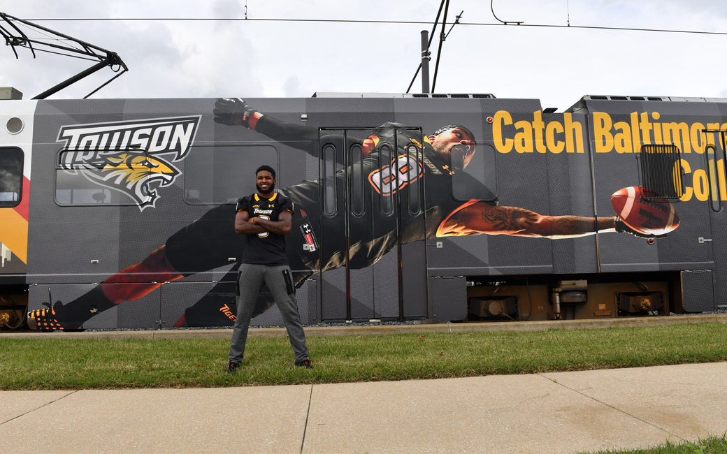 Monty Fenner outside a Light Rail Train with his photo on it