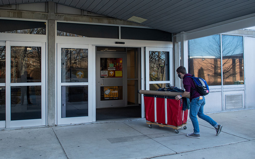 Student pushes cart into doors