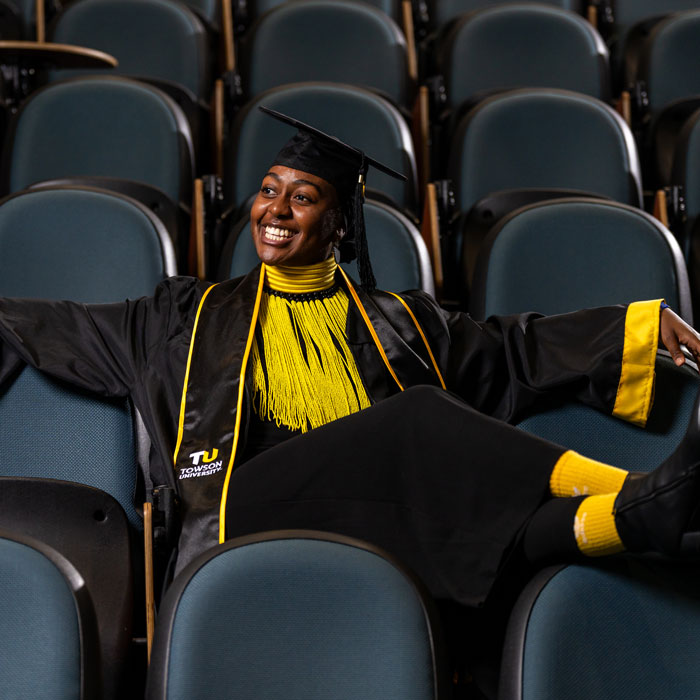 Rose Marika Mwansa sits wearing commencement regalia