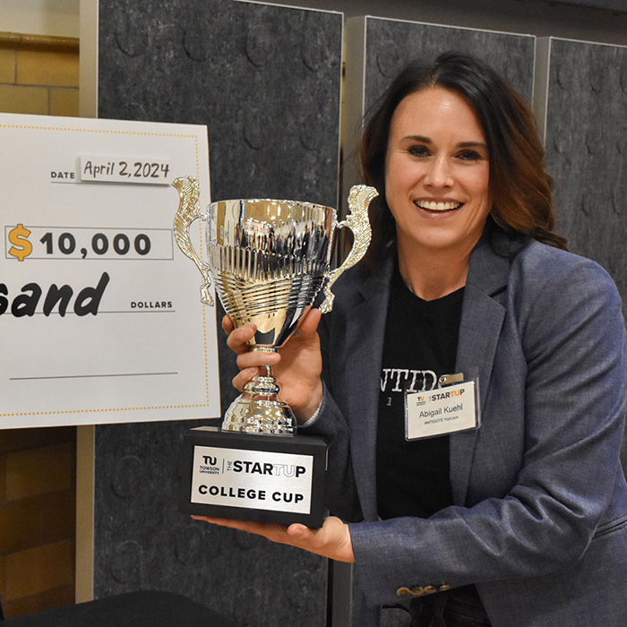 Abigail Kuehl holding her StartUp College Cup trophy